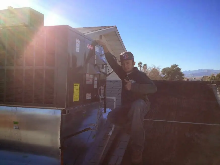 HVAC technician performing HVAC Inspection on a rooftop unit in Lowell